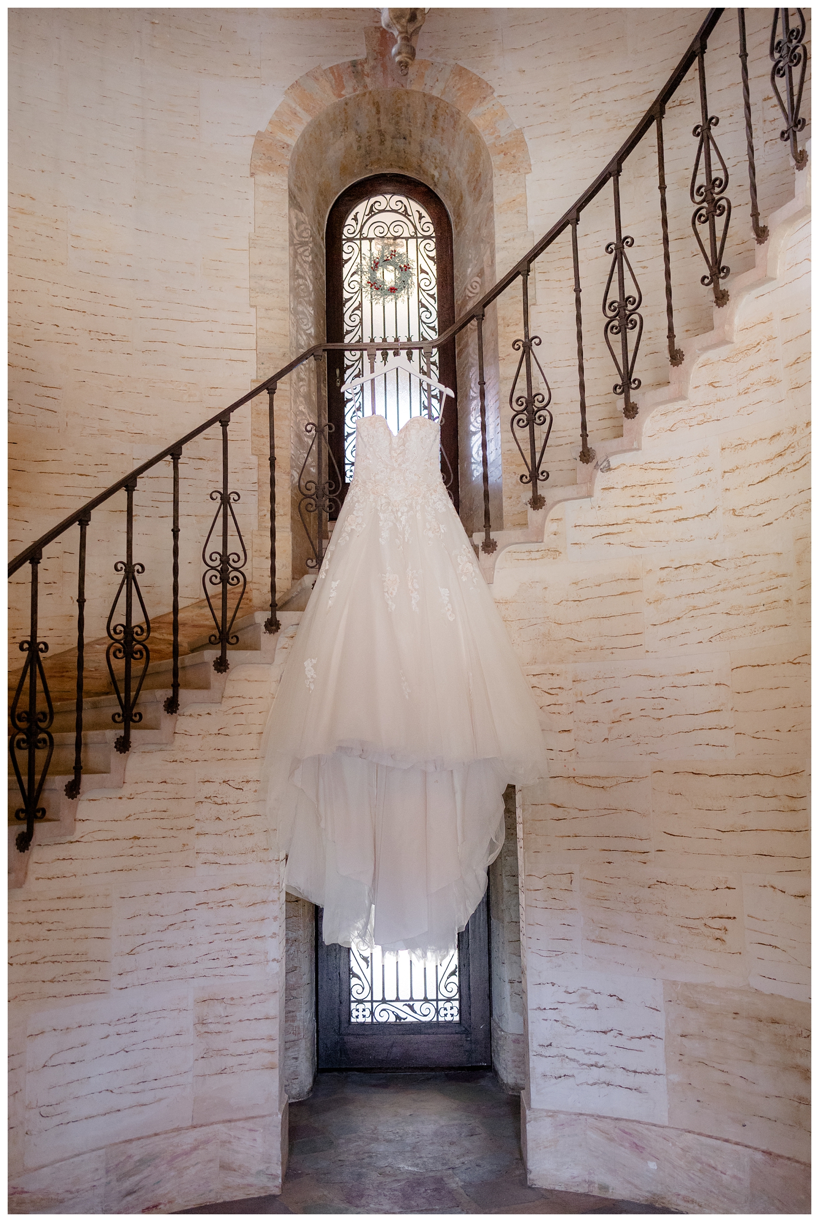 Wedding dress hanging on spiral staircase