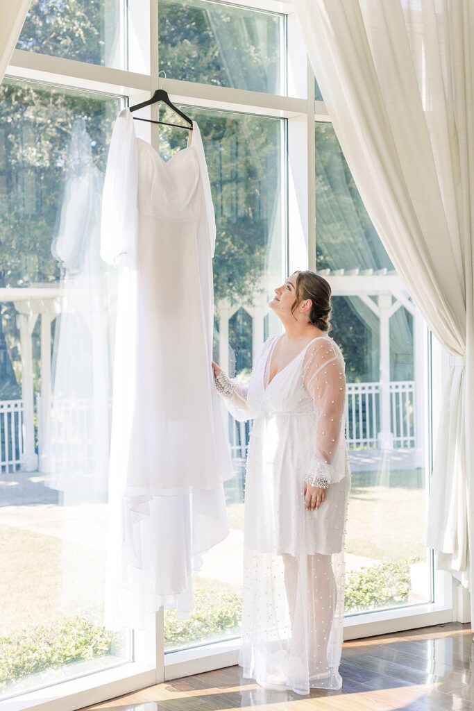 Bride admiring her wedding dress the morning before the wedding day
