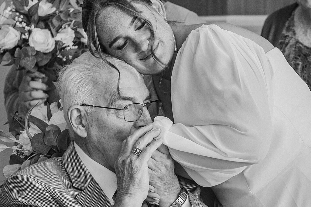 Brides grandfather kissing brides hand after seeing her for first time