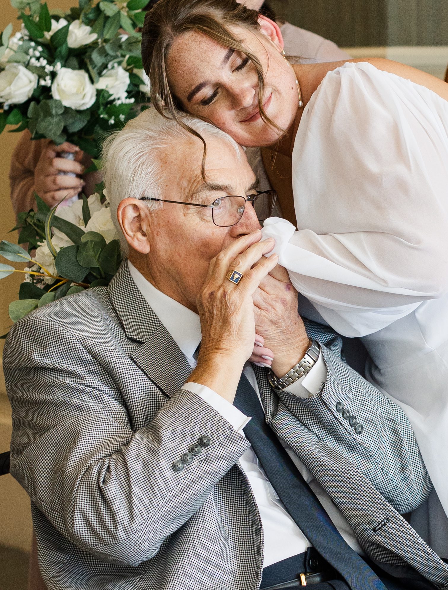 grandfather kissing brides hand on wedding day