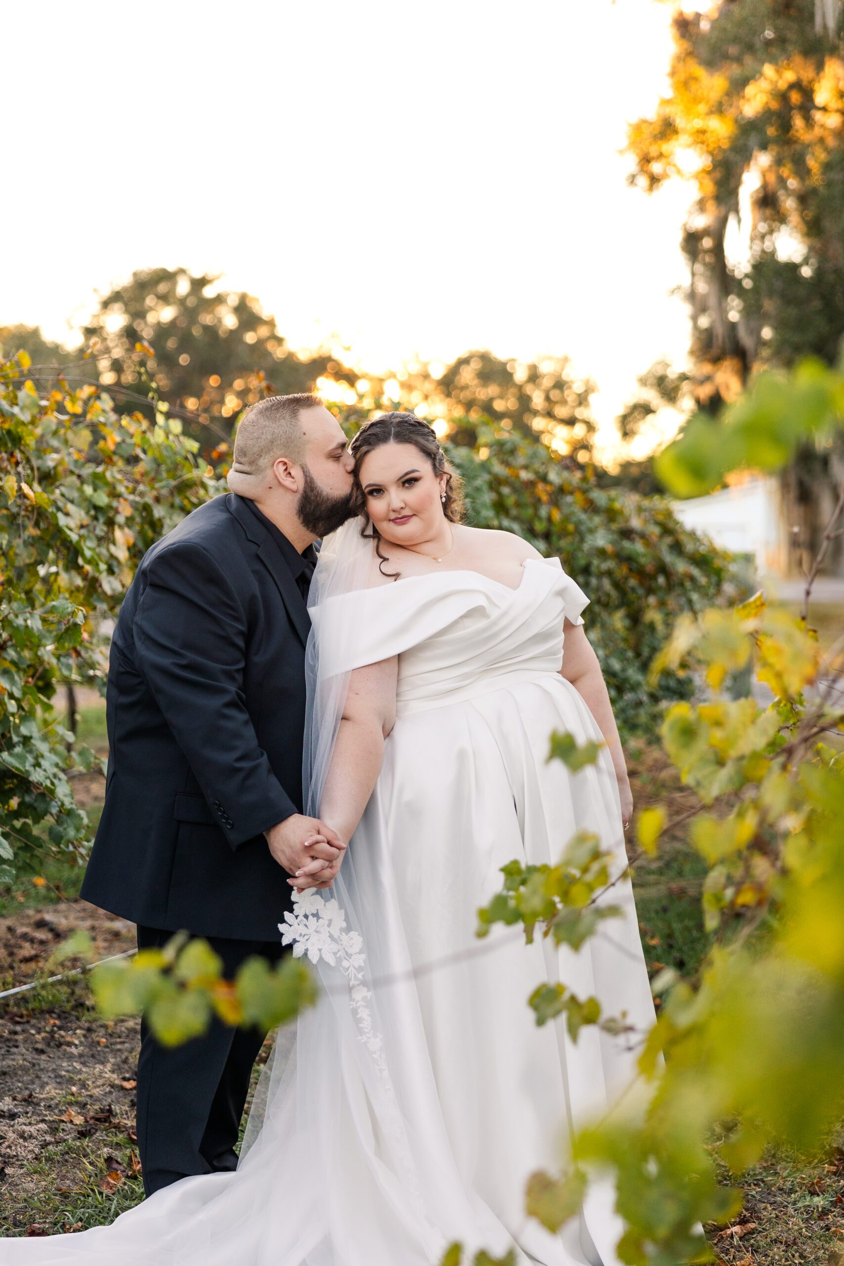 Groom Kissing Bride during Wedding Portraits