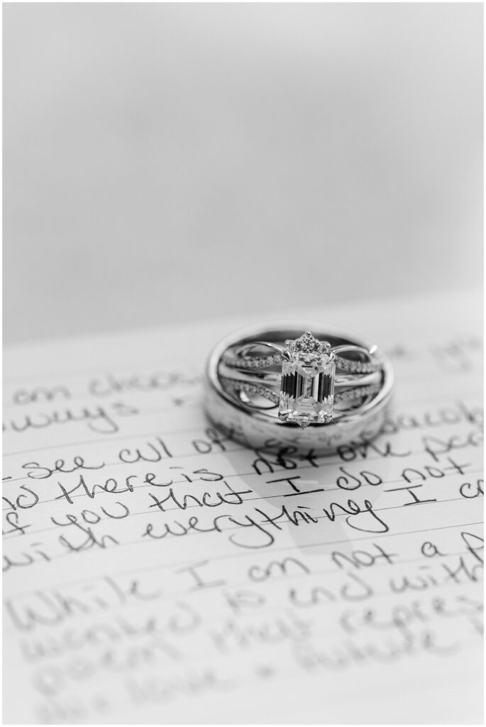 A detail photo of the wedding rings on top of the couples vows