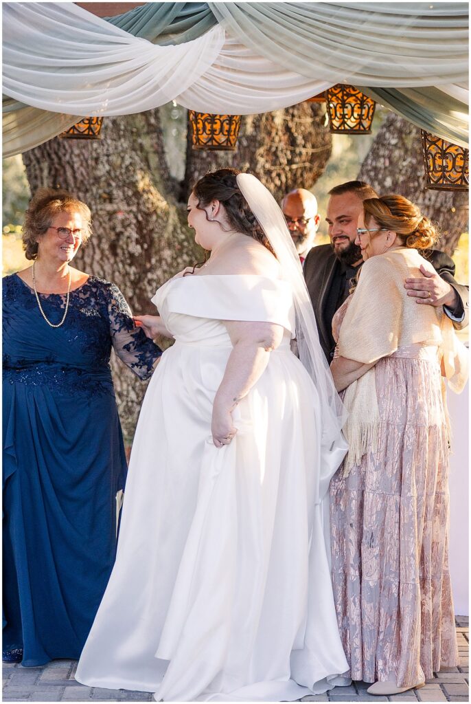 Bride & Groom hugging moms during ceremony
