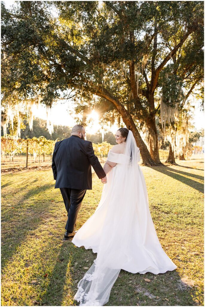 Bride and Groom walking into sunset at ever after farms wedding